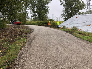 October 2019 - View looking north. Access road to the soil piles completed to the first soil pile (soil 1 on the right side of the photo). Staff preparing to remove the cover to allow waste characterization sample collection.
