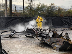 October 2019 - Site 108 - view looking northwest.  Steel decontamination pad with high pressure steam cleaner utilized to remove tar residuals from the tank steel. 