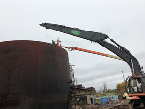 October 2019 - Site 108 - view looking west.  Dry run for tank cutting operation.  The manlift was used for transport and to evaluate reach and access. Long reach excavator was used to bring the cut pieces down from the top and side of the tank. 