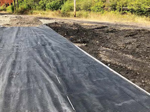 September 2019 - View looking southwest. Geogrid material combined with geotextile fabric shown in the photo for decon pad area. Aggregate placed on top in a 4-6-inch lift, graded and compacted.