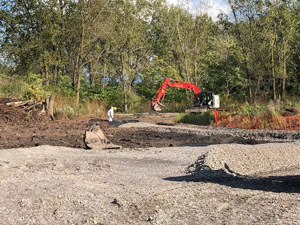 September 2019 - View looking northeast. Decon Pad area construction. Excavator used to install new access roadway from the access ramp to the decon area.